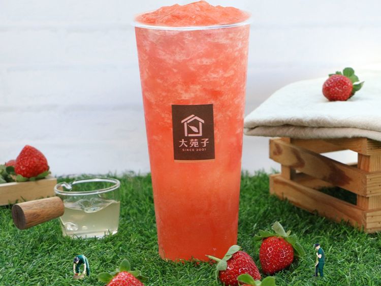 Pink Strawberry Beauty drink with strawberries on a grass mat